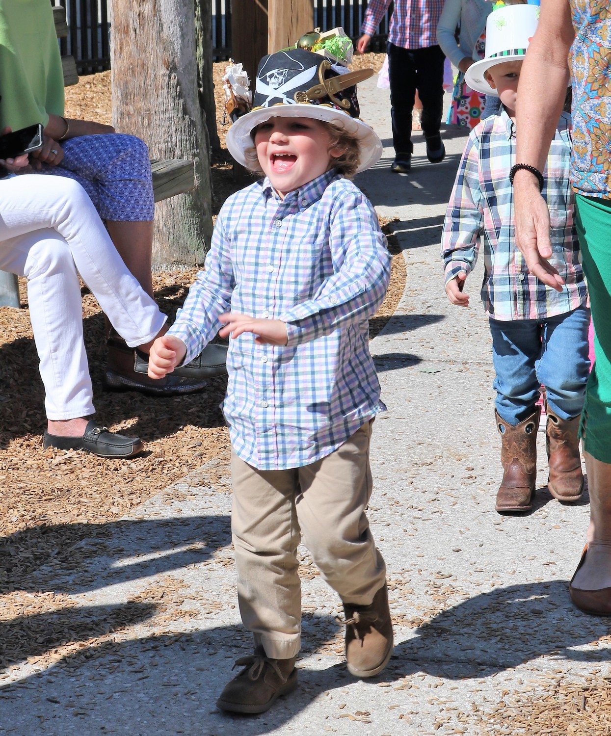 A boy laughs as he marches in his pirate-themed top hat.